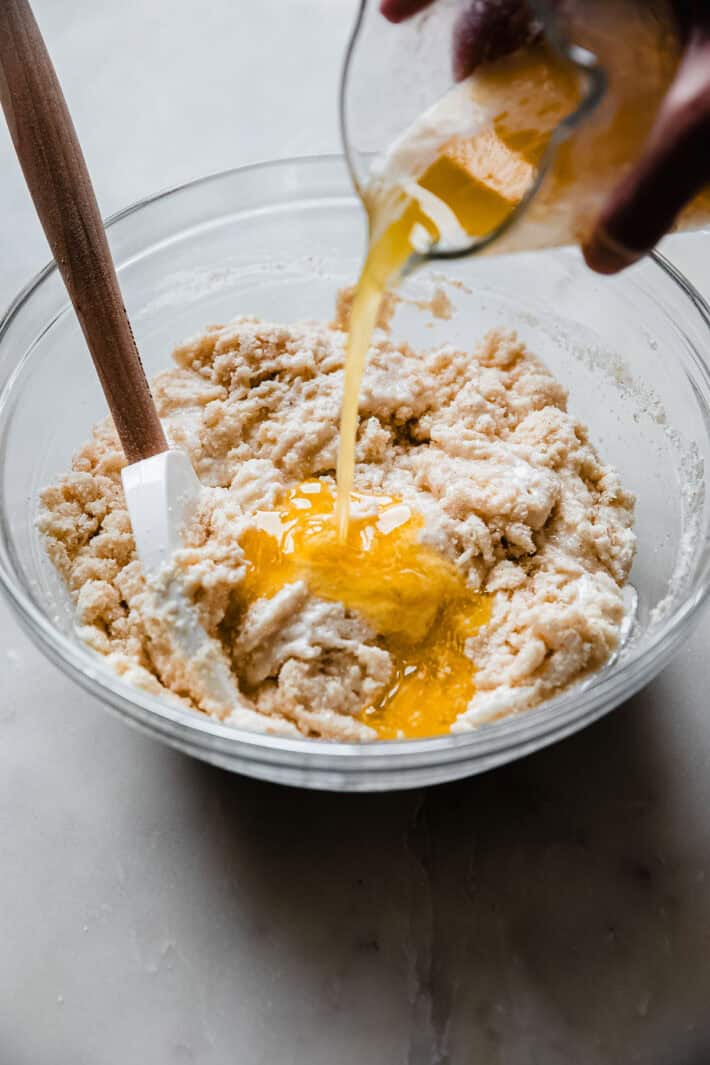 pouring melted butter into semolina cake batter