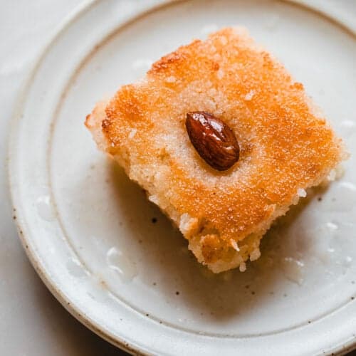 basbousa cake slice soaked in simple syrup with an almond on top