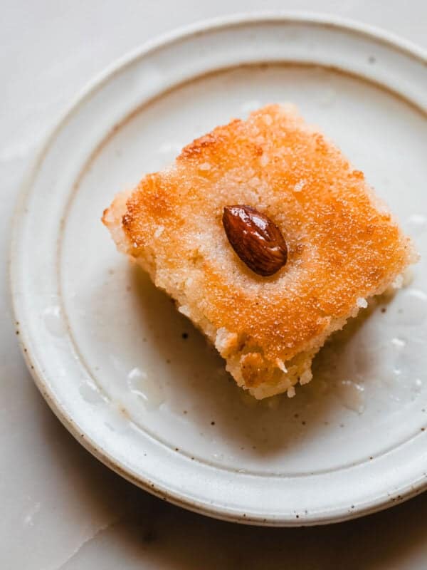 basbousa cake slice soaked in simple syrup with an almond on top