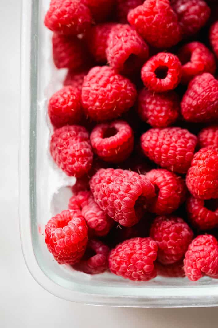 washed raspberries in a glass container