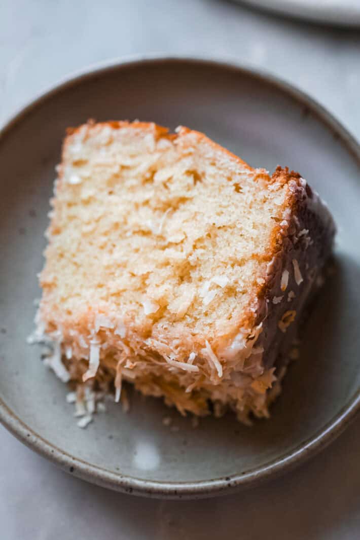 sliced bundt cake with glaze and shredded coconut