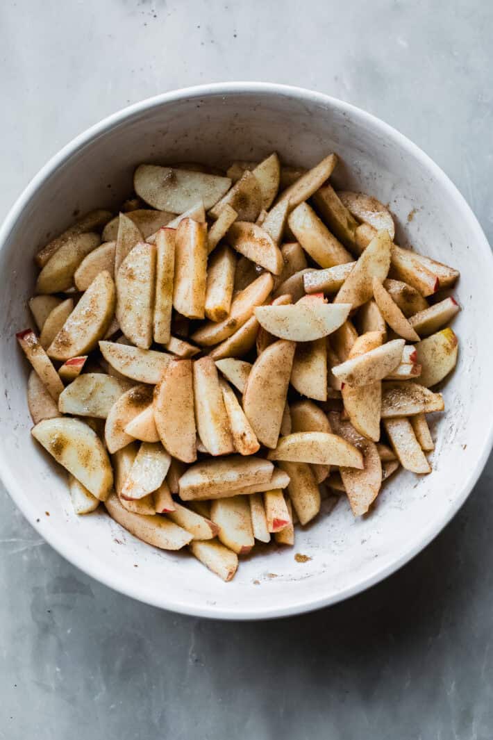 sliced apples with sugar, lemon and cinnamon in bowl