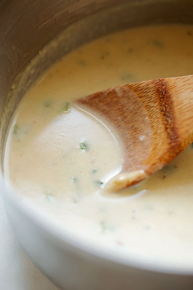 poblano cream sauce in pan with wooden spoon