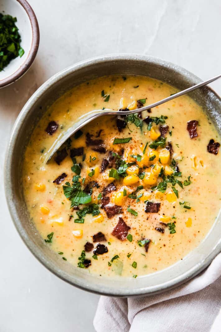 Fresh Corn Zucchini Chowder - The perfect way to use up all that summer produce! Creamy chowder loaded with fresh corn and zucchini and chopped jalapeños! #cornchowder #chowder #zucchinichowder | Littlespicejar.com corn chowder with zucchini in bowl with spoon