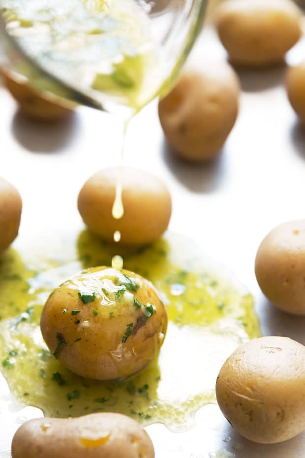 drizzling garlic butter over potatoes