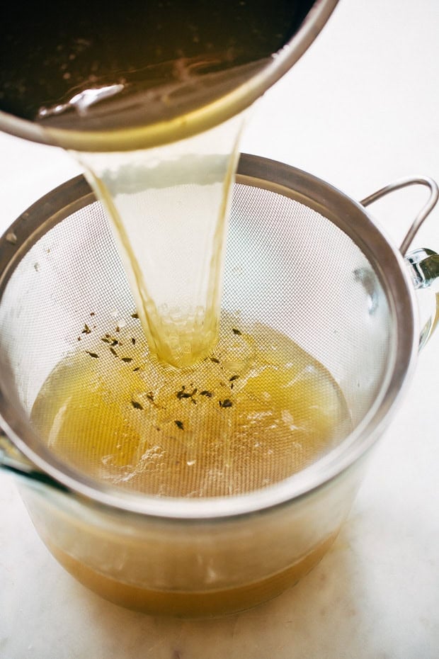 straining broth into measuring cup
