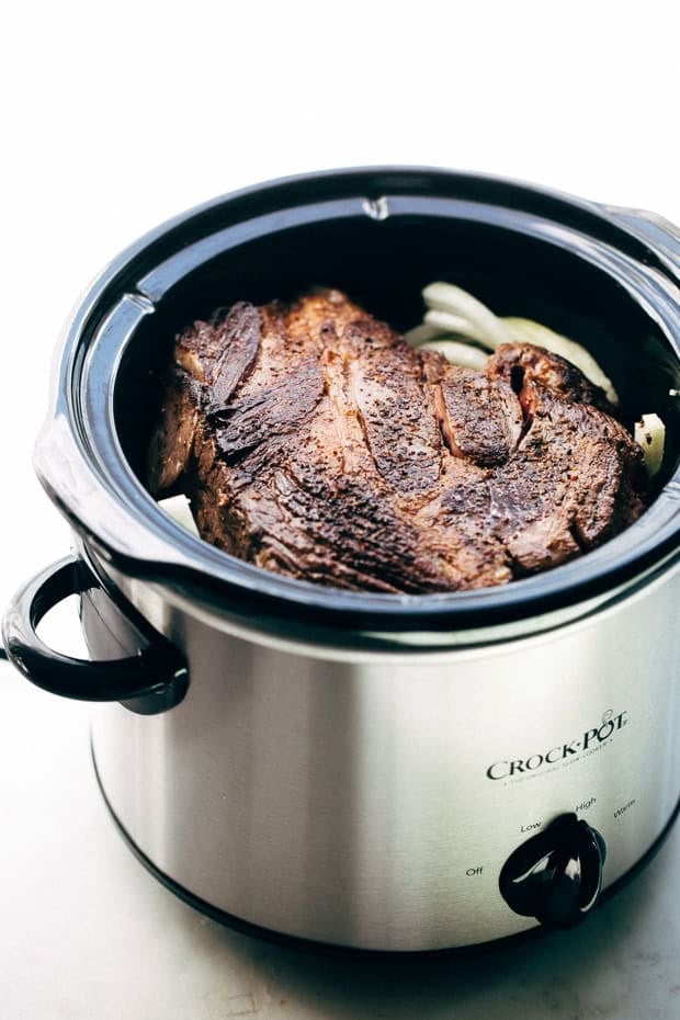 crock with pot roast on top before cooking