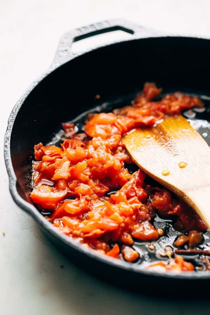 sautéing tomatoes in a cast iron skillet