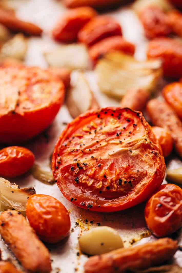 roasted tomatoes carrots and onions on baking sheet