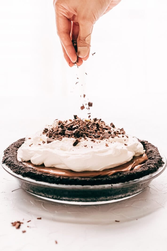 sprinkling chocolate shavings onto pie