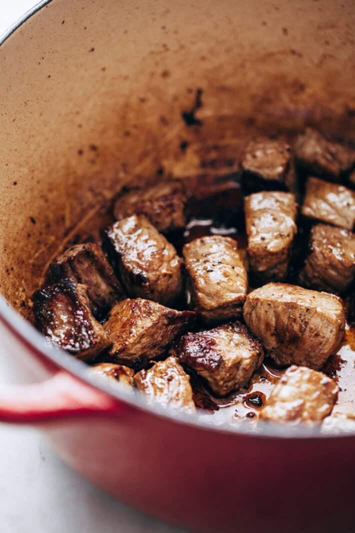 seared stew meat in cast iron pot