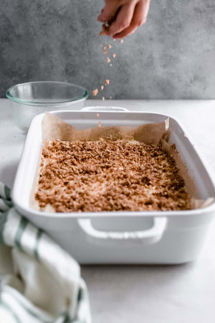 sprinkling pecan crumble over coffee cake