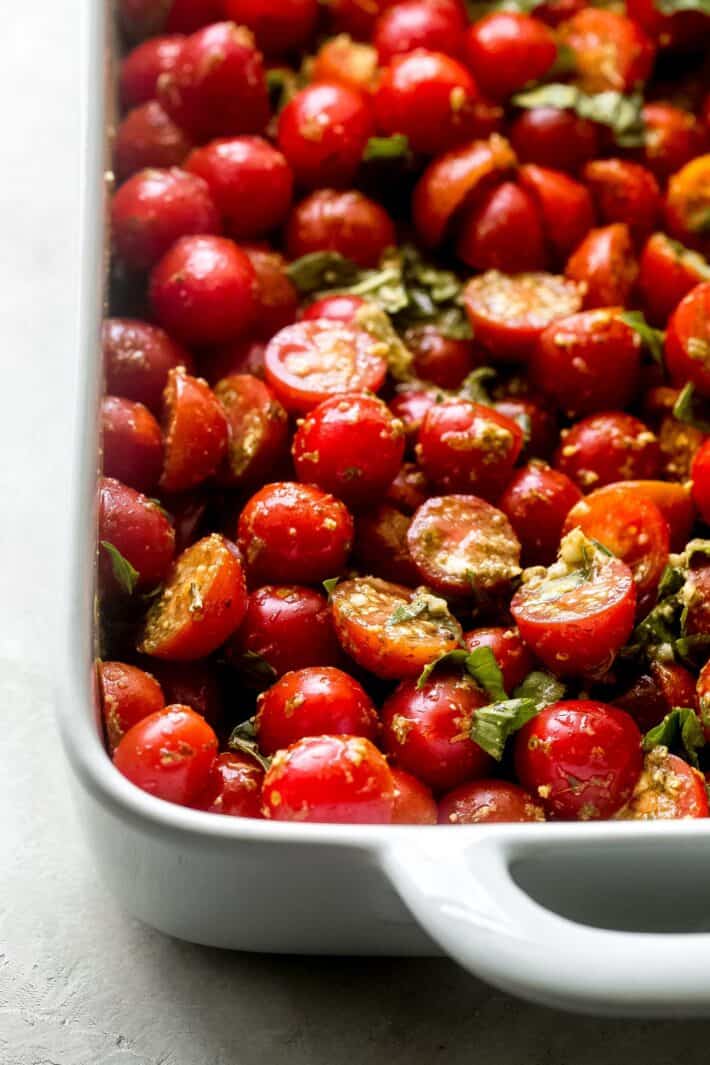 marinated tomatoes in baking dish with pesto
