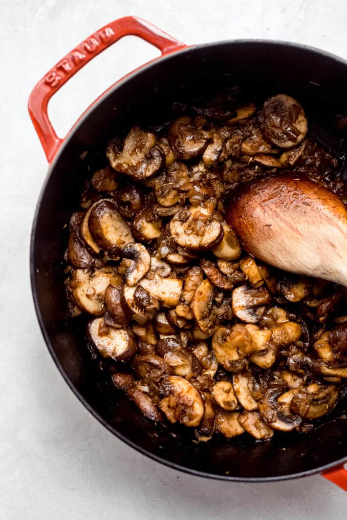 sautéed mushrooms in a pot with wooden spoon