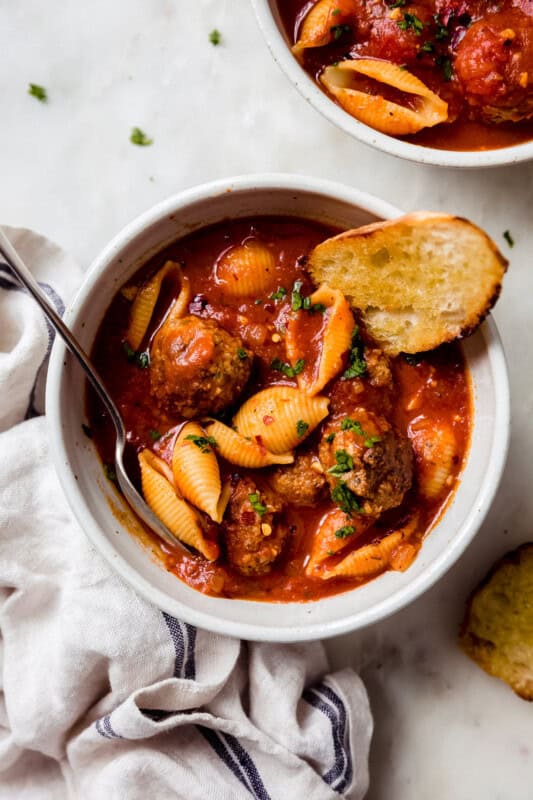 meatballs in tomato soup base with shell pasta and spoon