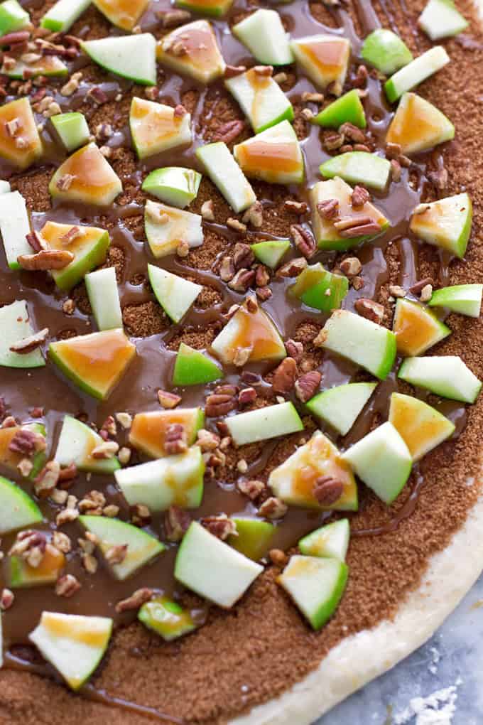 dough covered with brown sugar cinnamon, granny smit appleas, pecans, and caramel sauce