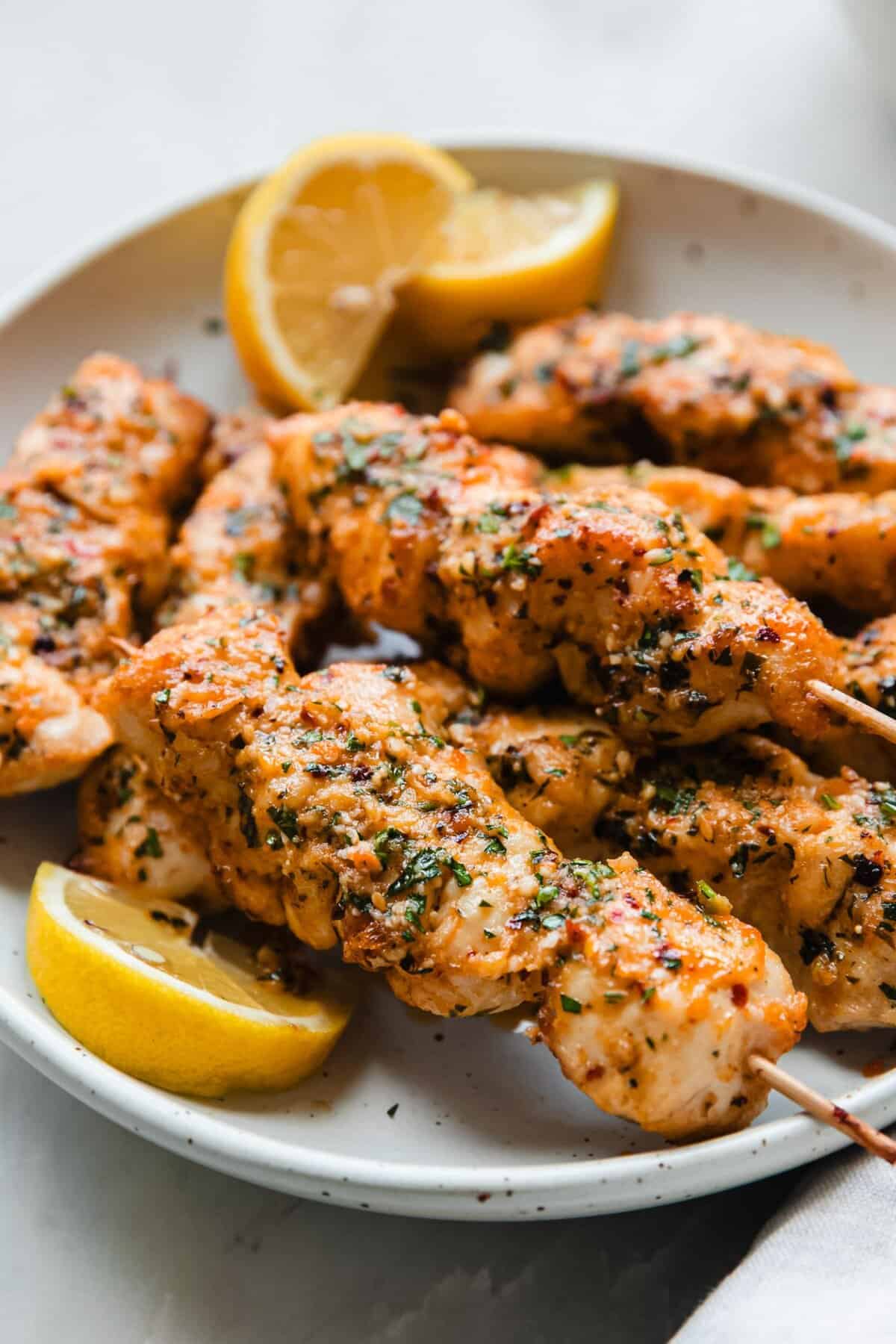 Garlic Parmesan grilled chicken breasts with golden Parmesan crust garlic butter and fresh parsley on a plate