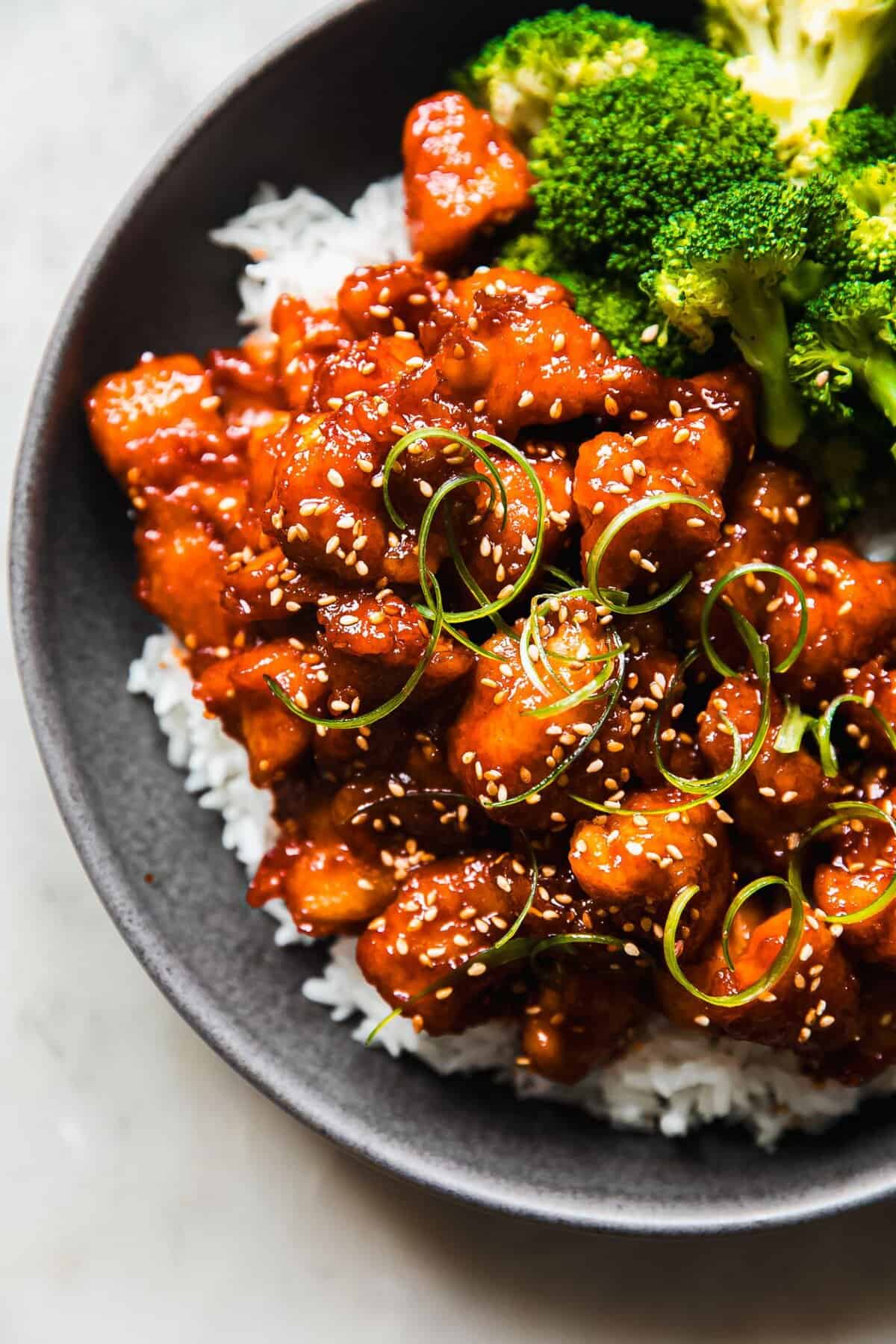 Gochujang glazed air fryer halal chicken breast with deep mahogany Korean chili glaze over rice and cold pickled cucumber for bold weeknight dinner
