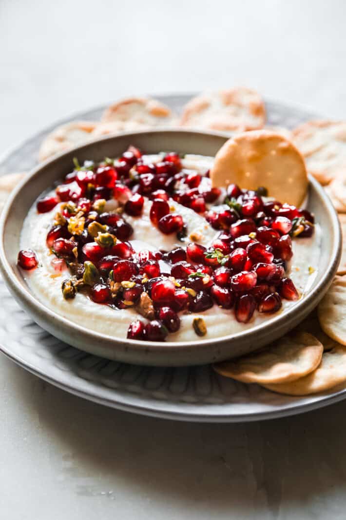 cracker resting in whipped ricotta dip bowl
