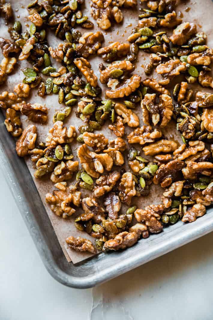candied walnuts and pepitas on baking sheet with parchment