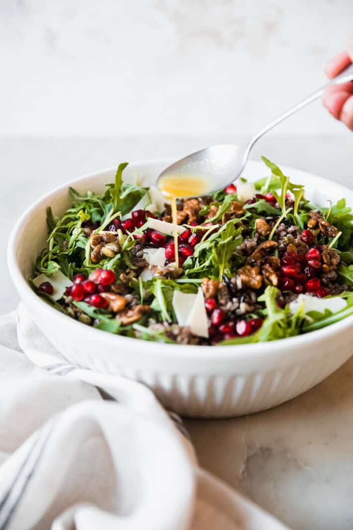 drizzling dressing over salad