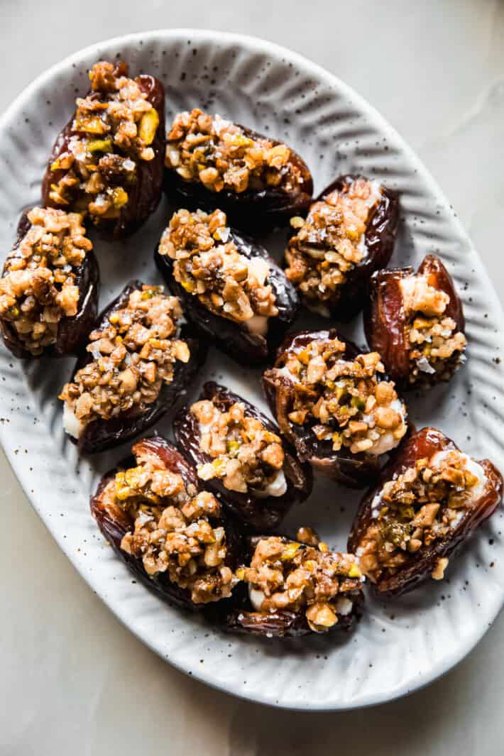pitted dates with nut topping on speckled plate