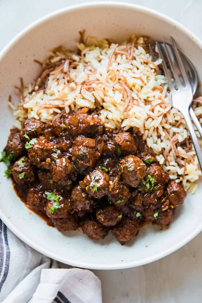 stew and vermicelli rice in bowl with fork and spoon