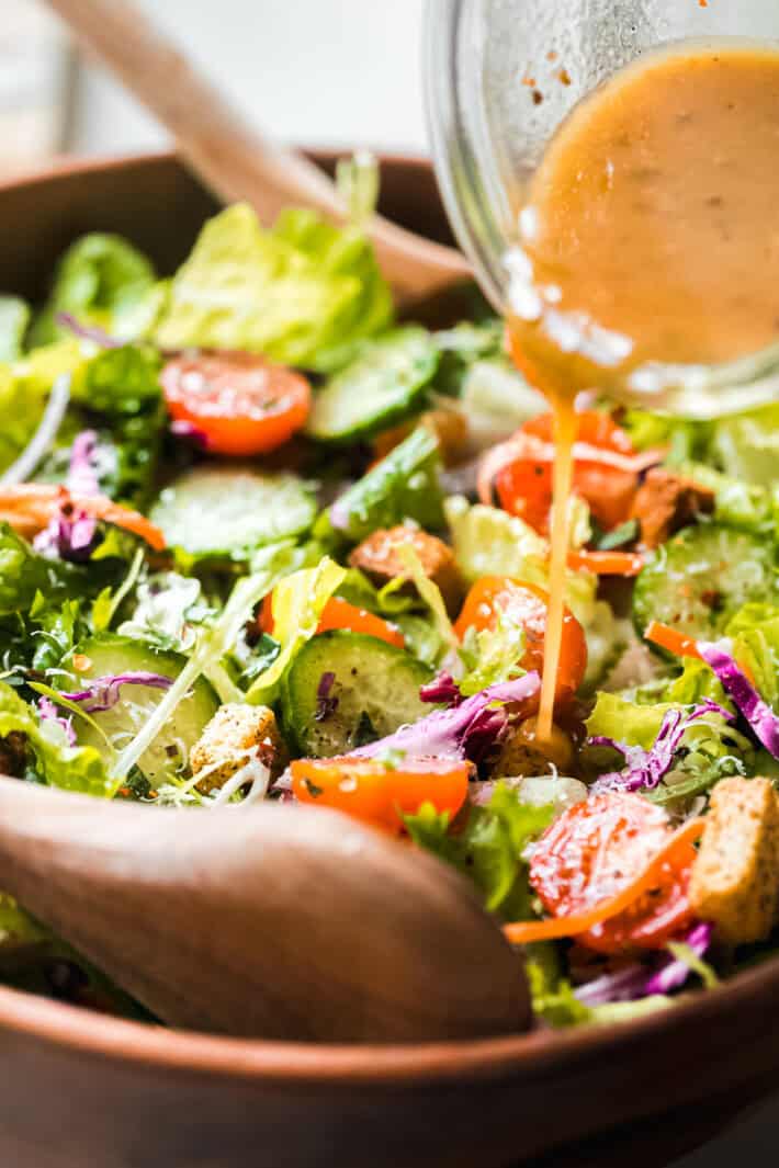 pouring dressing over salad