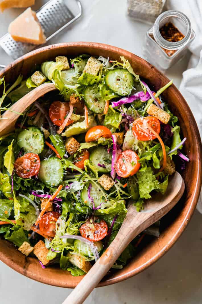 house salad in wooden bowl with wooden spoons
