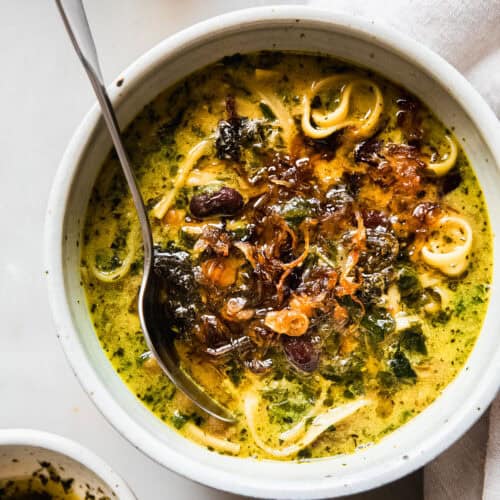 ashe reshteh in bowl with caramelized onions on top