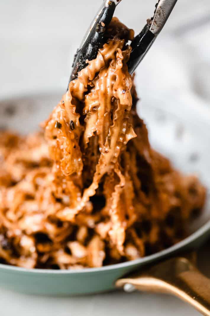 locking tongs holding soy noodles