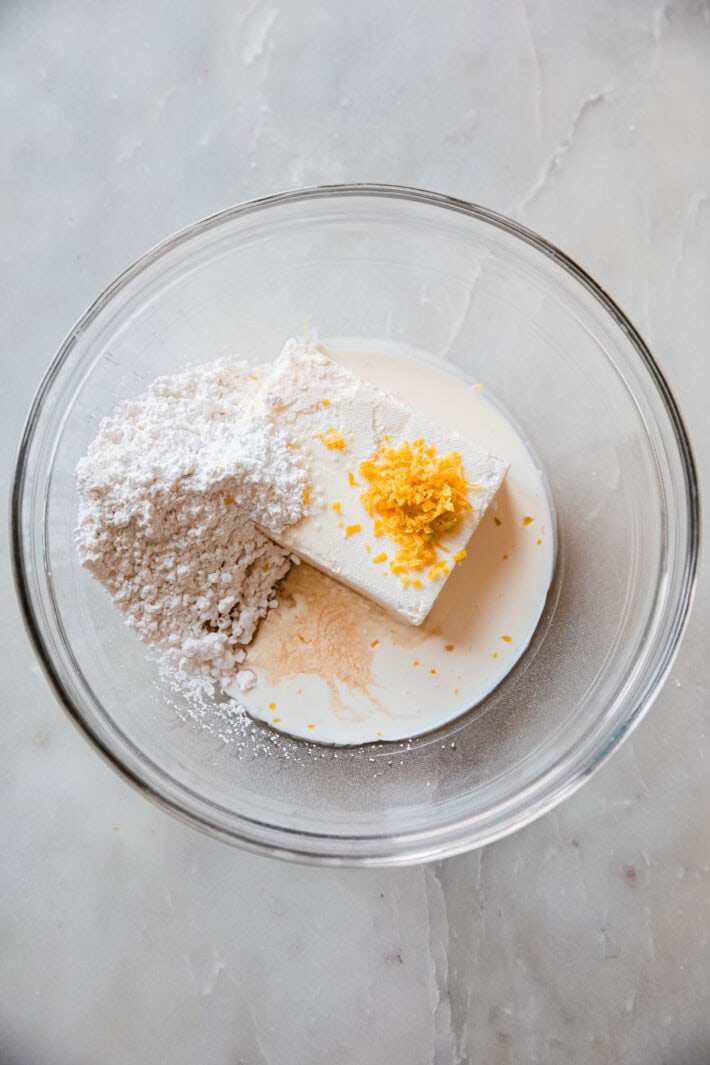 soften cream cheese, powdered sugar, heavy cream, vanilla, and lemon zest in bowl