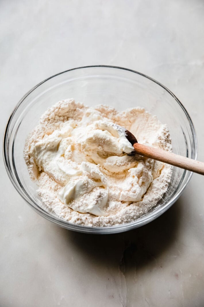 greek yogurt stirring into flour mixture for naan