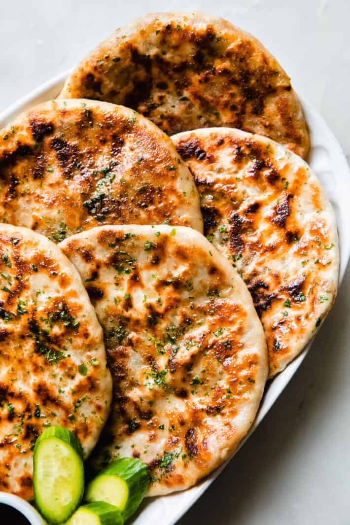 prepared ground beef stuffed naan on tray with cucumbers