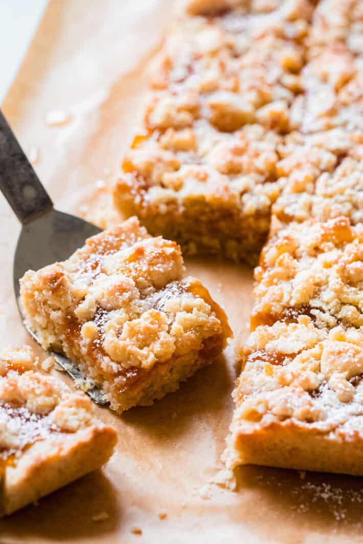 cut apricot crumble bars on brown parchment paper