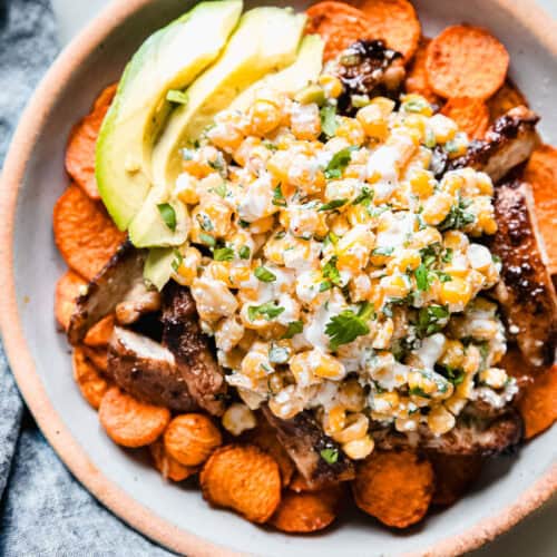 street corn bowls with sliced chicken and avocados in bowl