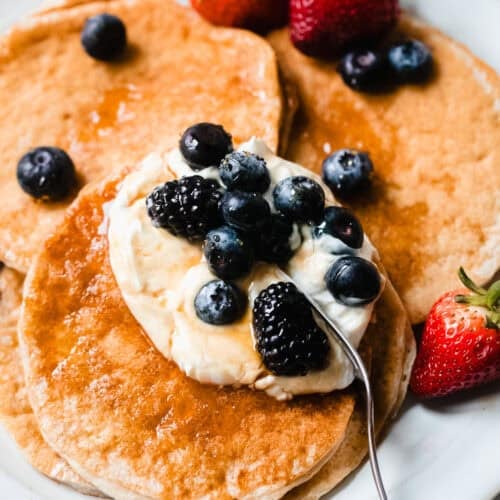 cottage cheese protein pancakes on plate with berries and syrup