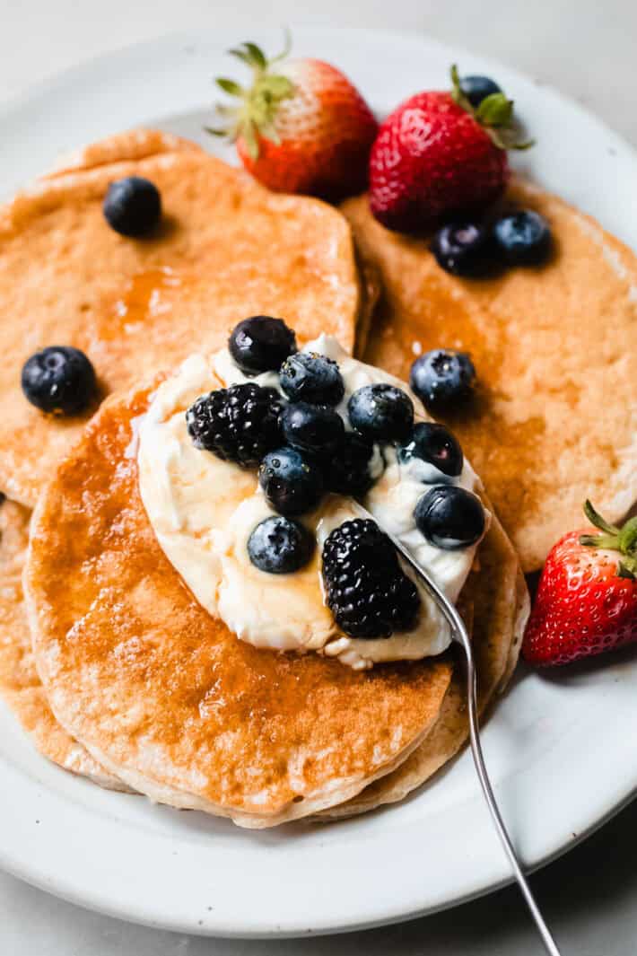 cottage cheese protein pancakes on plate with berries and syrup