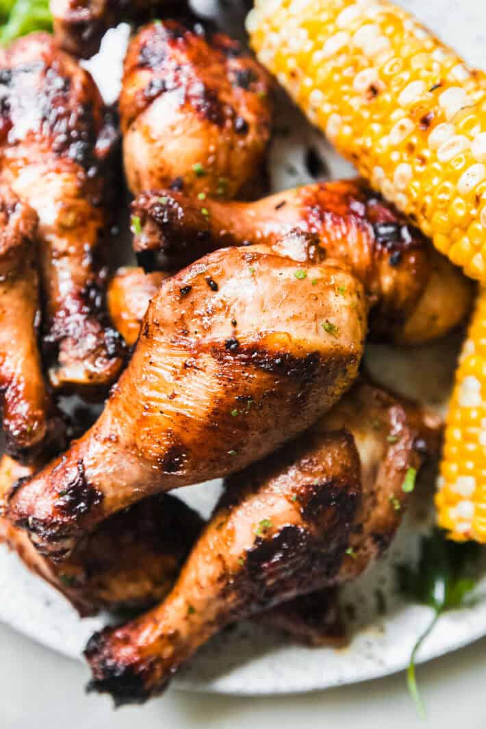 grilled chicken drumsticks on plate with fire roasted corn