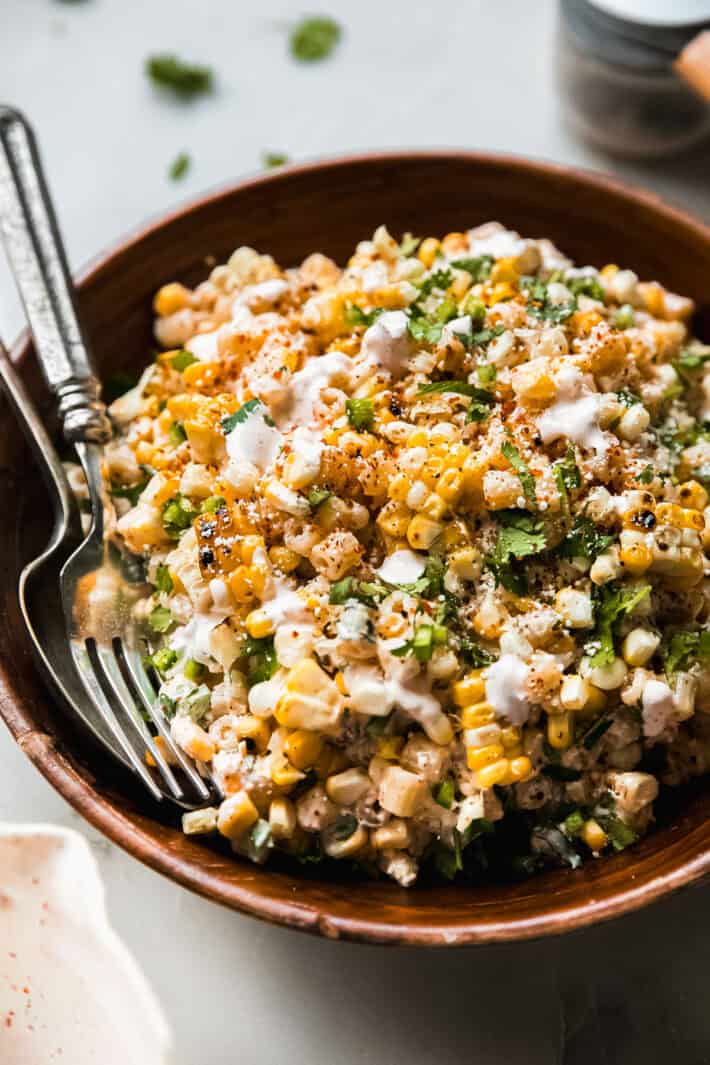 elotes pasta salad in bowl with fork and spoon