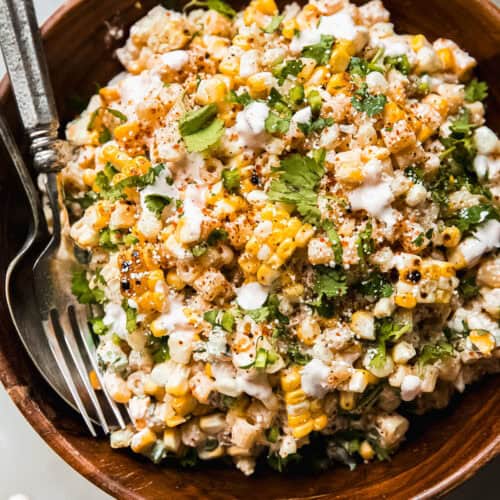 street corn pasta salad in wooden bowl with spoon and fork