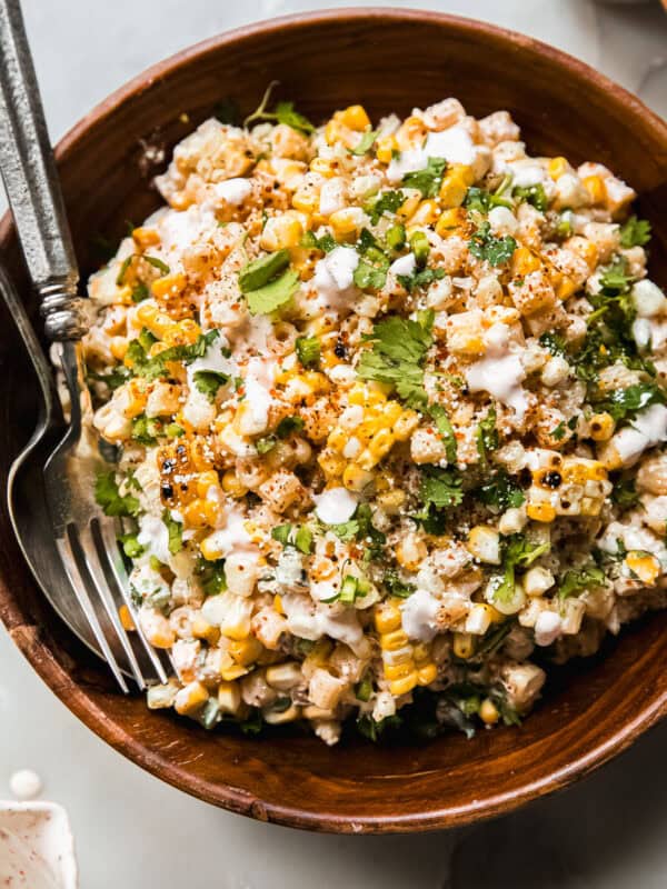 street corn pasta salad in wooden bowl with spoon and fork