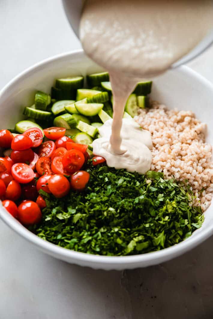lemon tahini dressing poured over rice salad