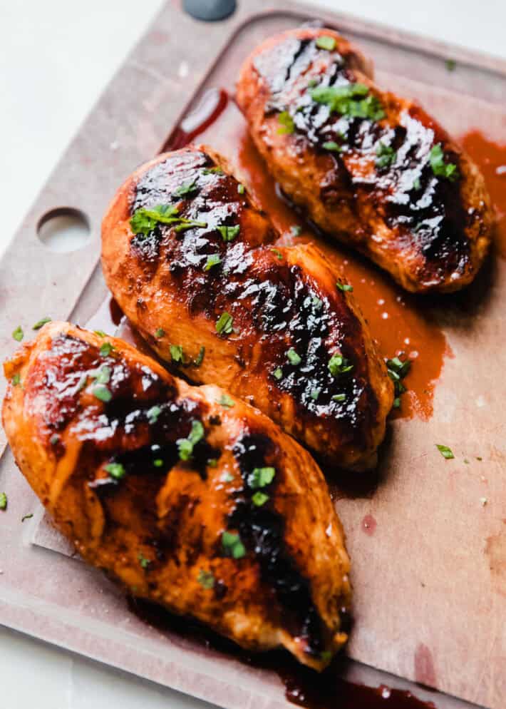 grilled honey lime chicken on cutting board before slicing