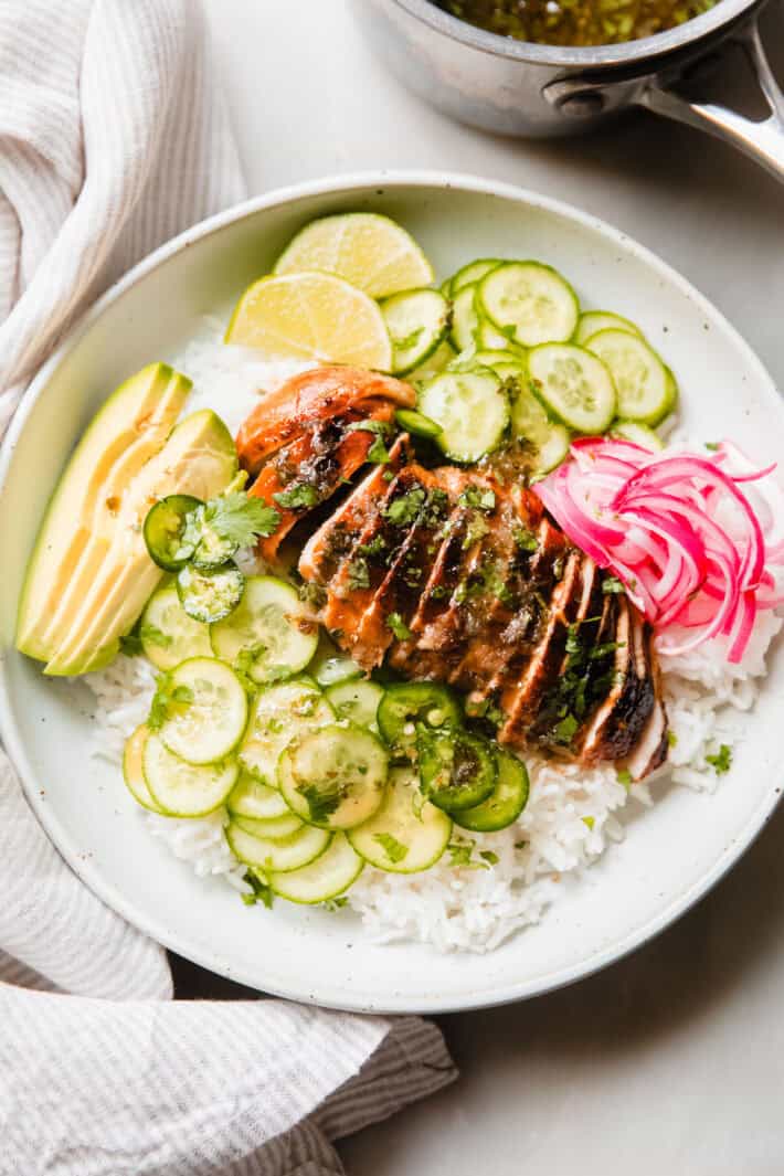 coconut rice with chicken on top with avocados and cucumbers