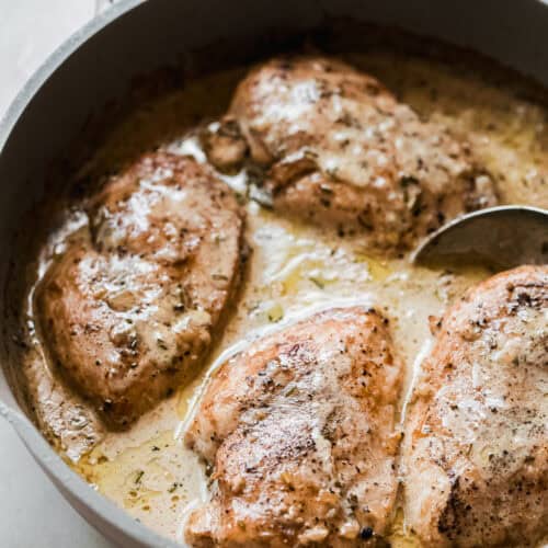 creamy peppercorn chicken in skillet with spoon