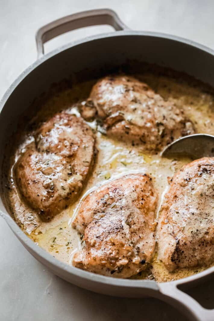 creamy peppercorn chicken in skillet with spoon