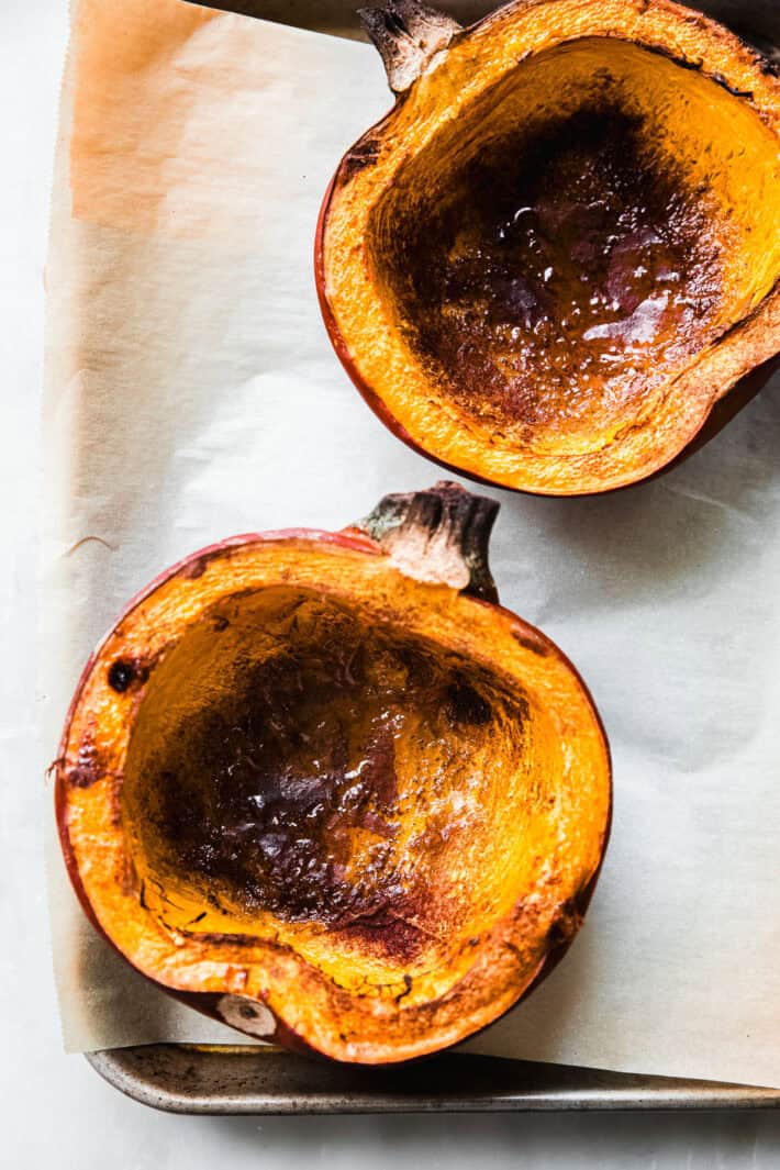 roasted pumpkin halves on baking sheet